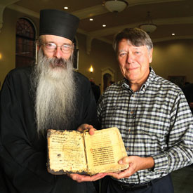 man poses with ancient book