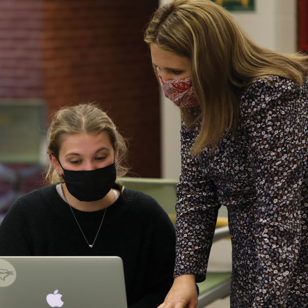UWC director, Dr. Kara Poe Alexander (right) helps a student writer.