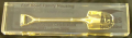 Gold-plated shovel encased in glass, 