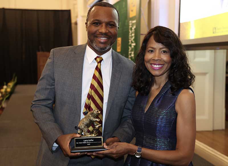 Monica Anderson, B.A. ’84 (R) presents the Distinguished Black Alumni Award to Larry W. Coffer II (L).
