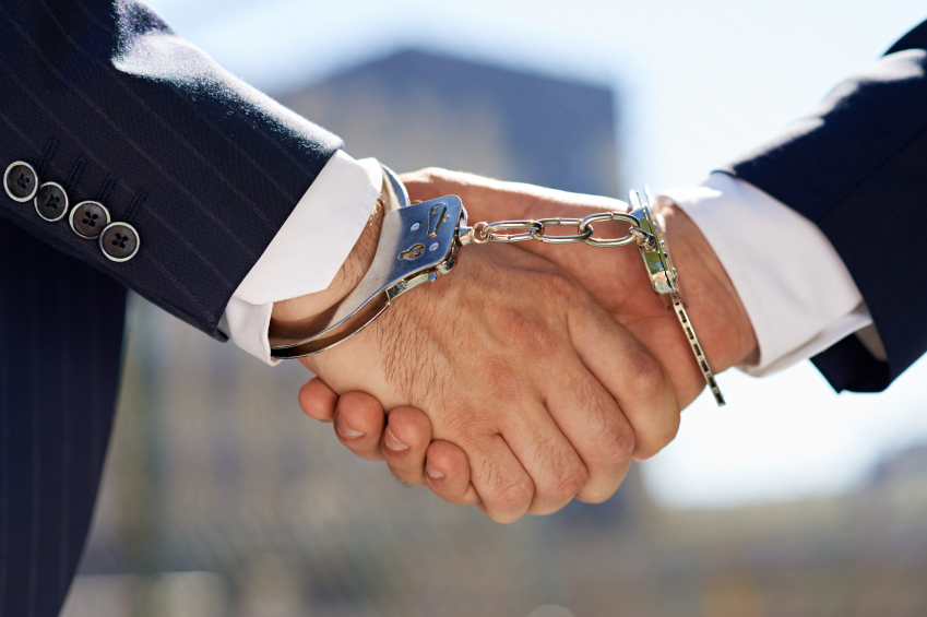Stock photo of a handshake between people handcuffed to one another