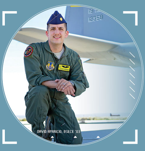 Major David Aparicio poses in a flight suit against a military plane