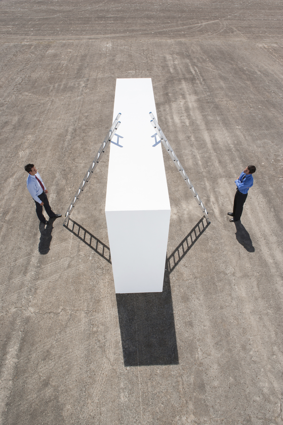 Stock photo representation of two people trying to scale a wall