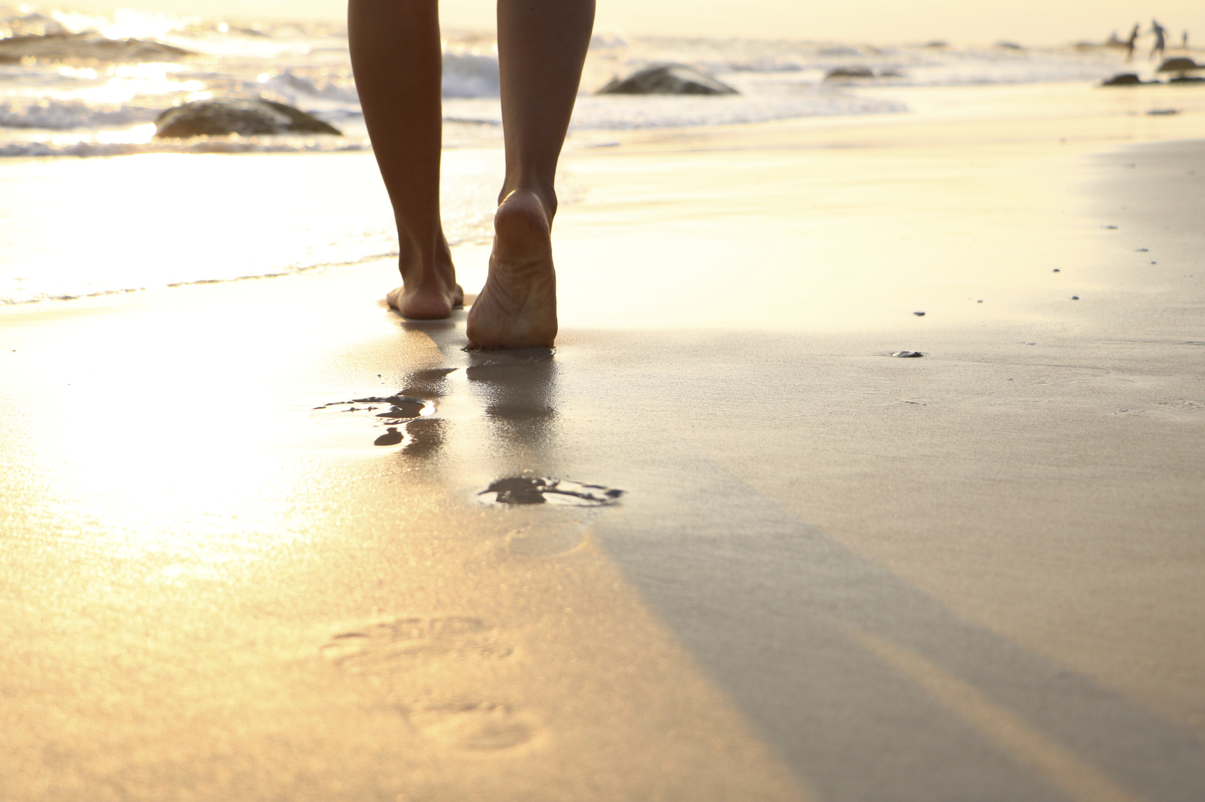 Stock photo of person walking on the beach