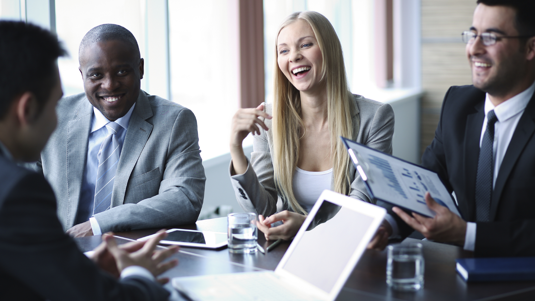 Stock photo of a business meeting with everyone laughing