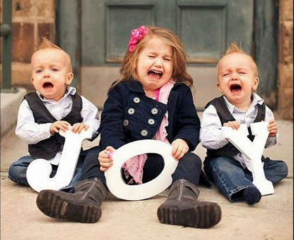 Photo of crying trio of toddlers, holding the letters, J, O, and Y
