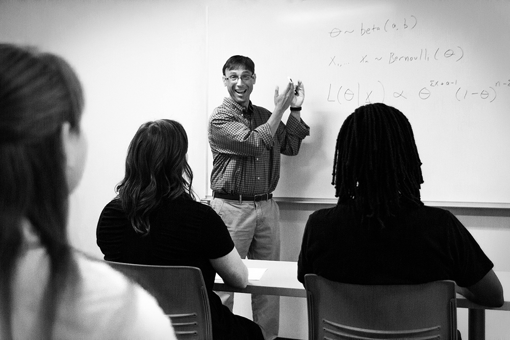 Professor stands at blackboard and teaches