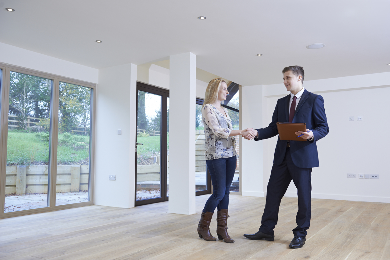 Stock photo of a man and a woman shaking hands in an empty house
