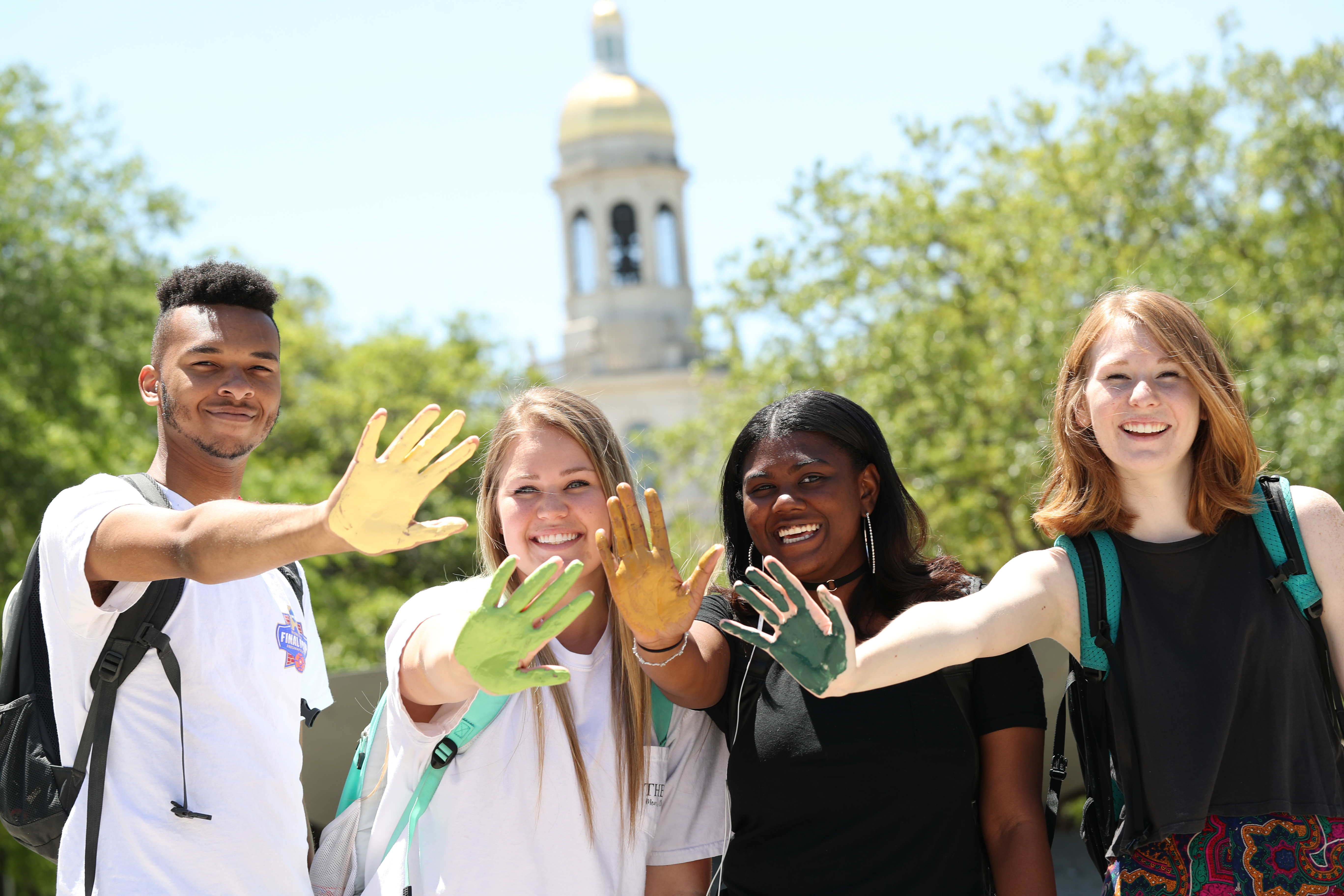 Photo of Baylor students with green and gold hands facing the camera