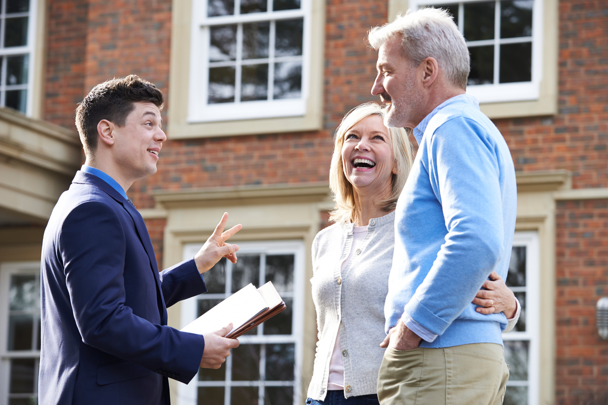 Stock photo of a businessman/realtor showing a home to an older couple