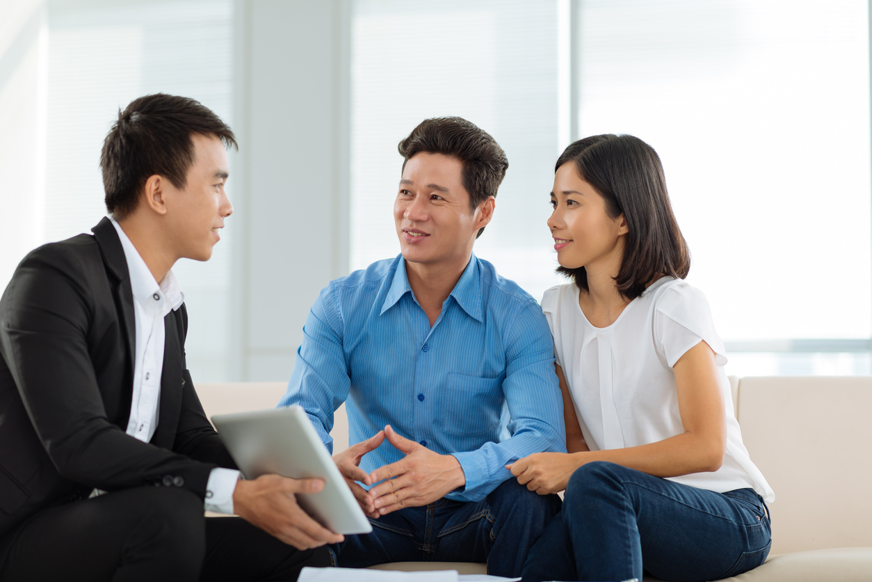 Stock Photo of a couple being guided on a tablet by a businessman