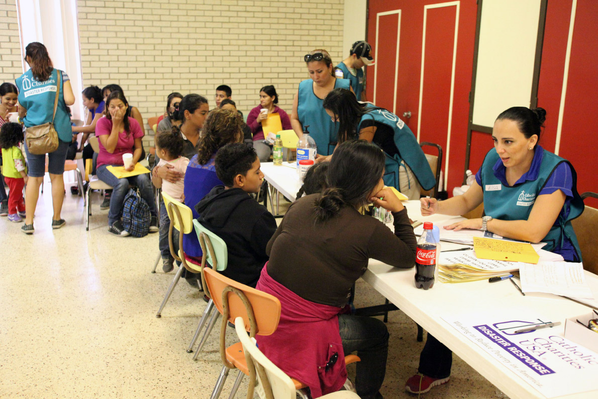 Disaster response team talks with a Central American refugee at the intake and orientation table