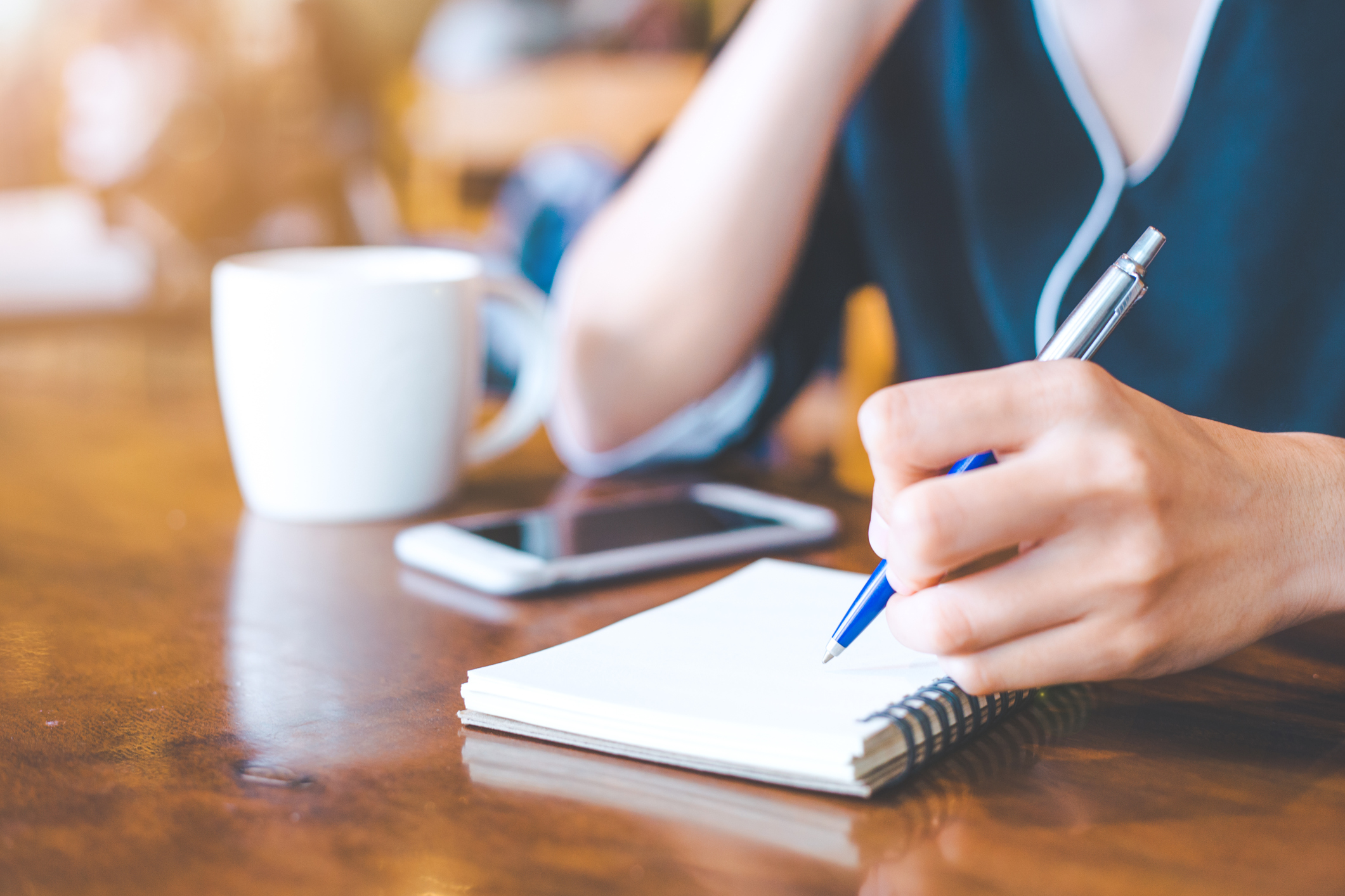 Stock photo of a hand writing with a pen on paper