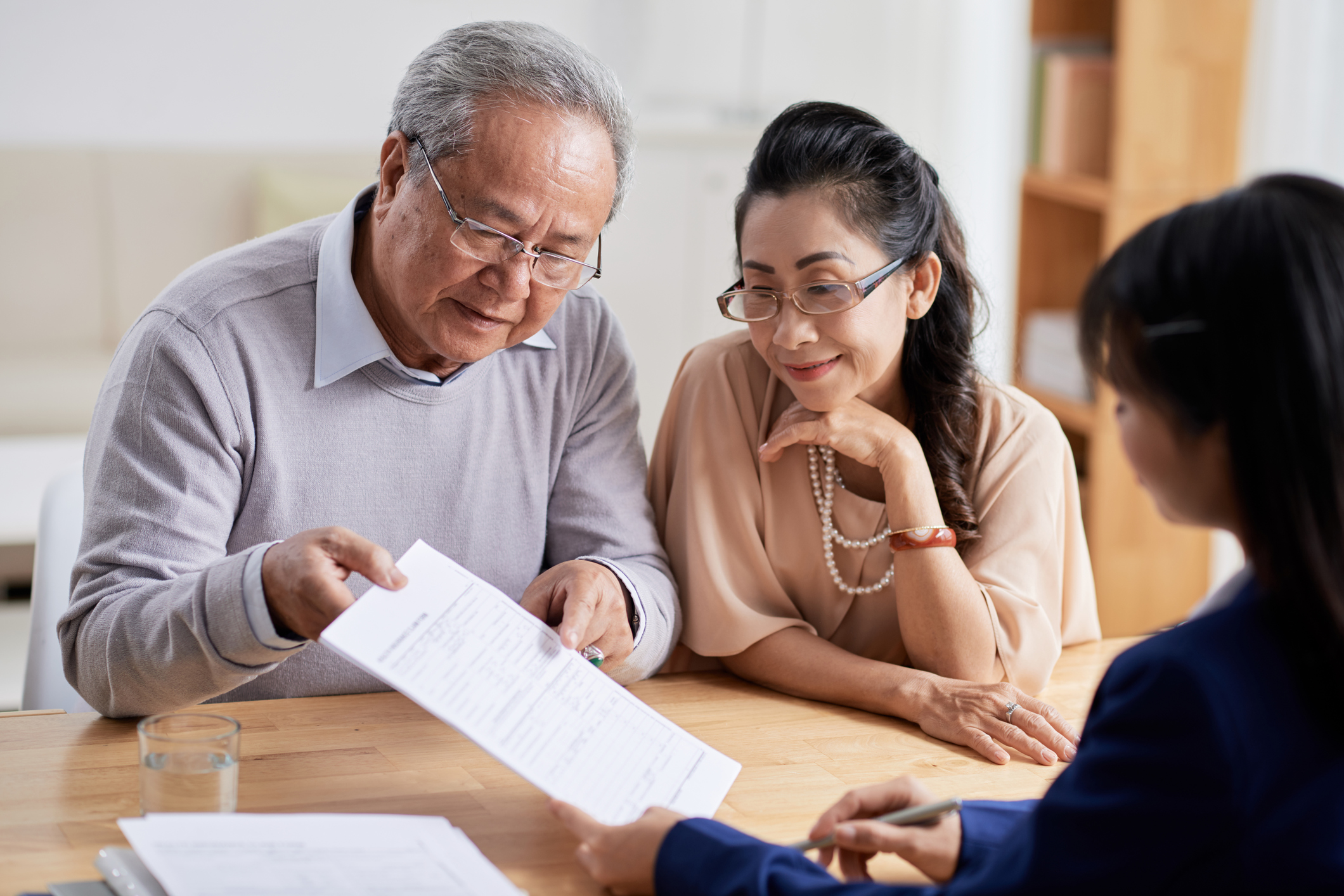 Stock photo of an aged couple looking over paperwork