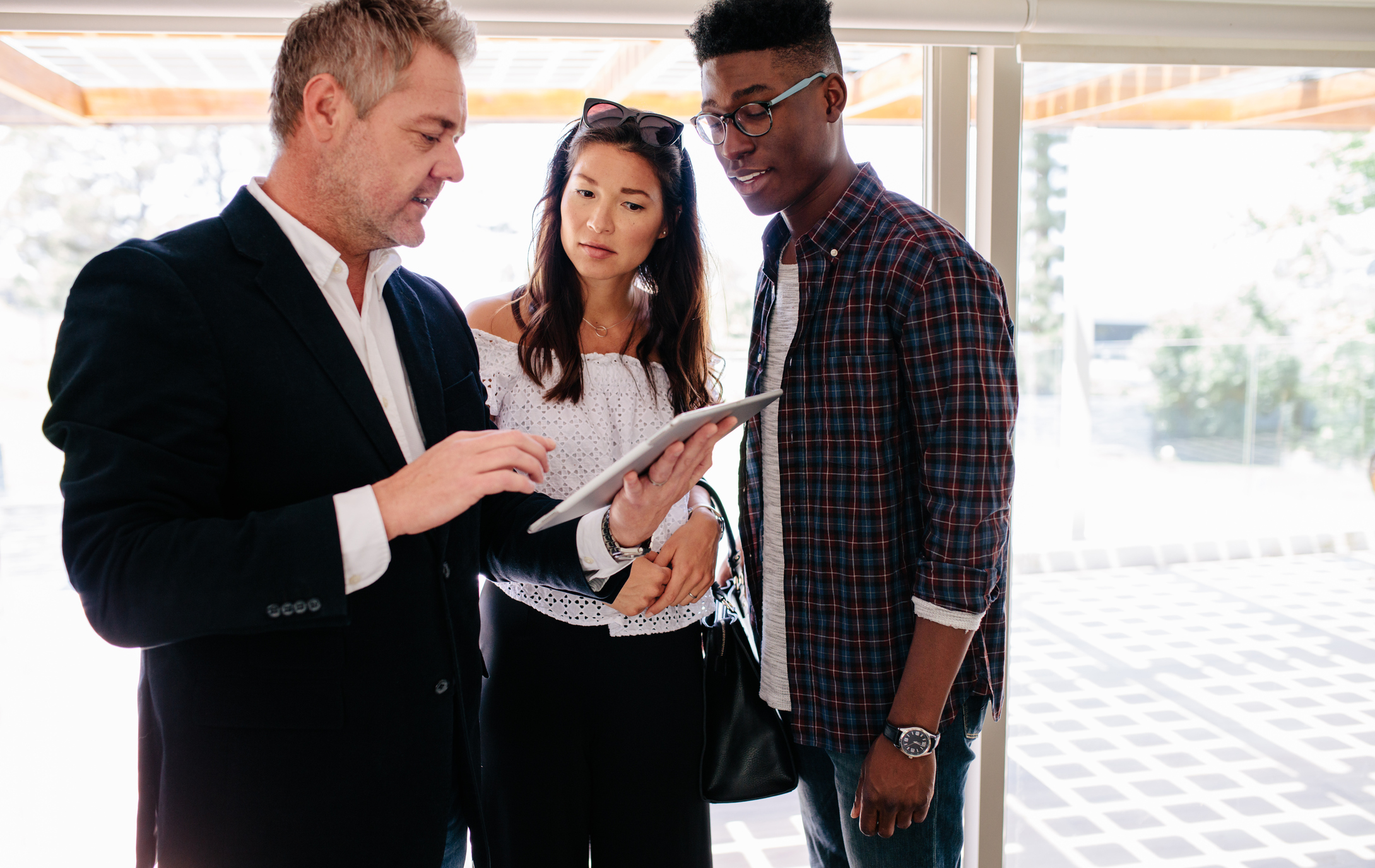 Stock photo of a couple looking a the tablet of a businessman