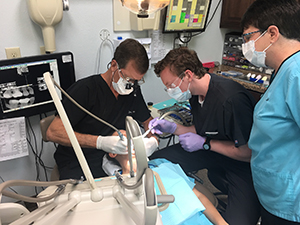 Dental students working on a test subject's teeth