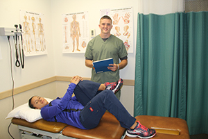 Two students demonstrate proper physical therapy techniques