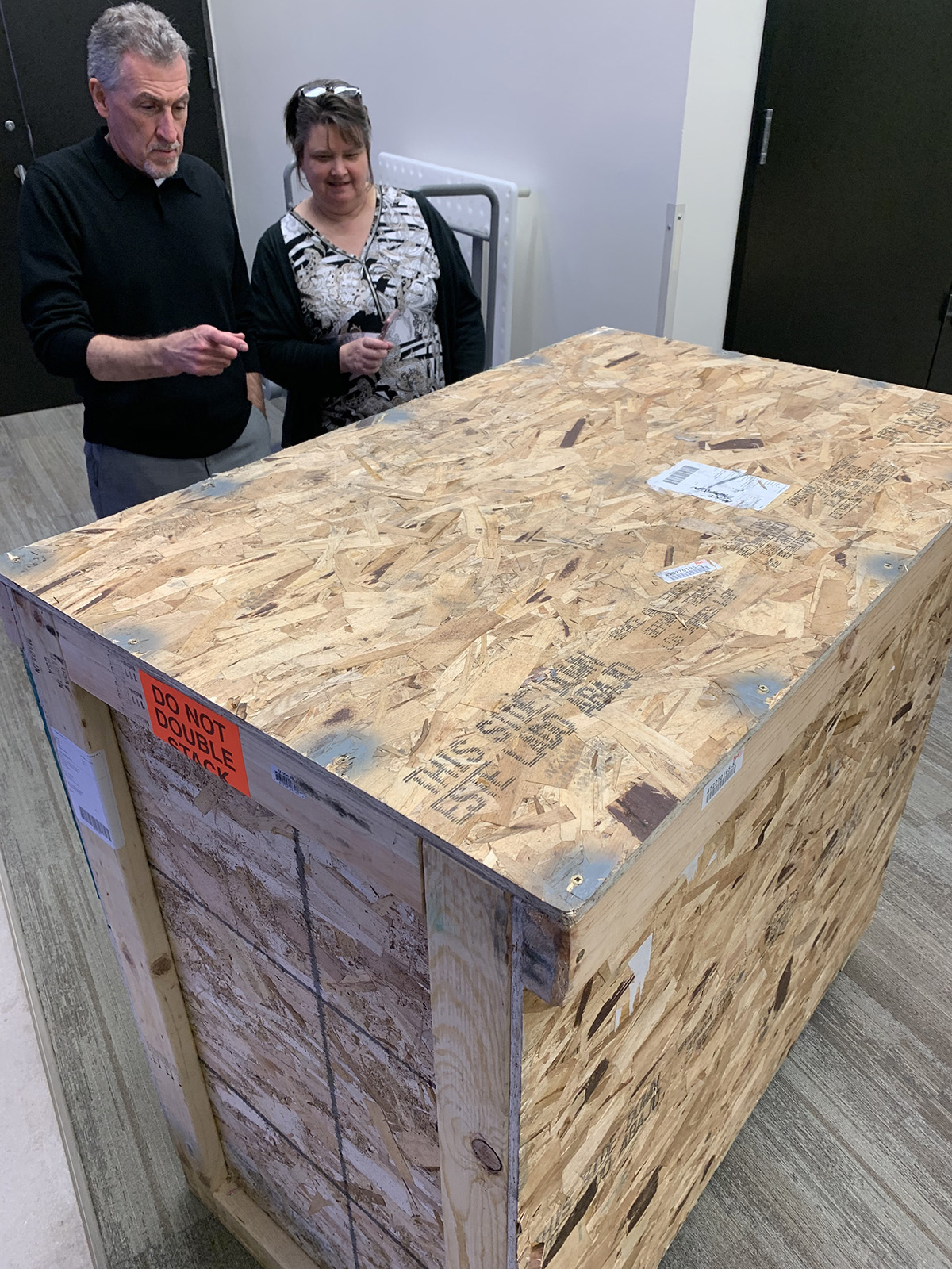 Interim Dean of University Libraries John S. Wilson and Director of Central Libraries' Special Collections Beth Farwell examine the shipping crate containing the St. John's Bible.