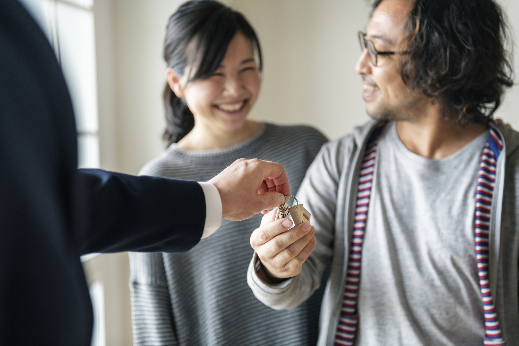 Stock photo of a couple receiving house keys from a realtor