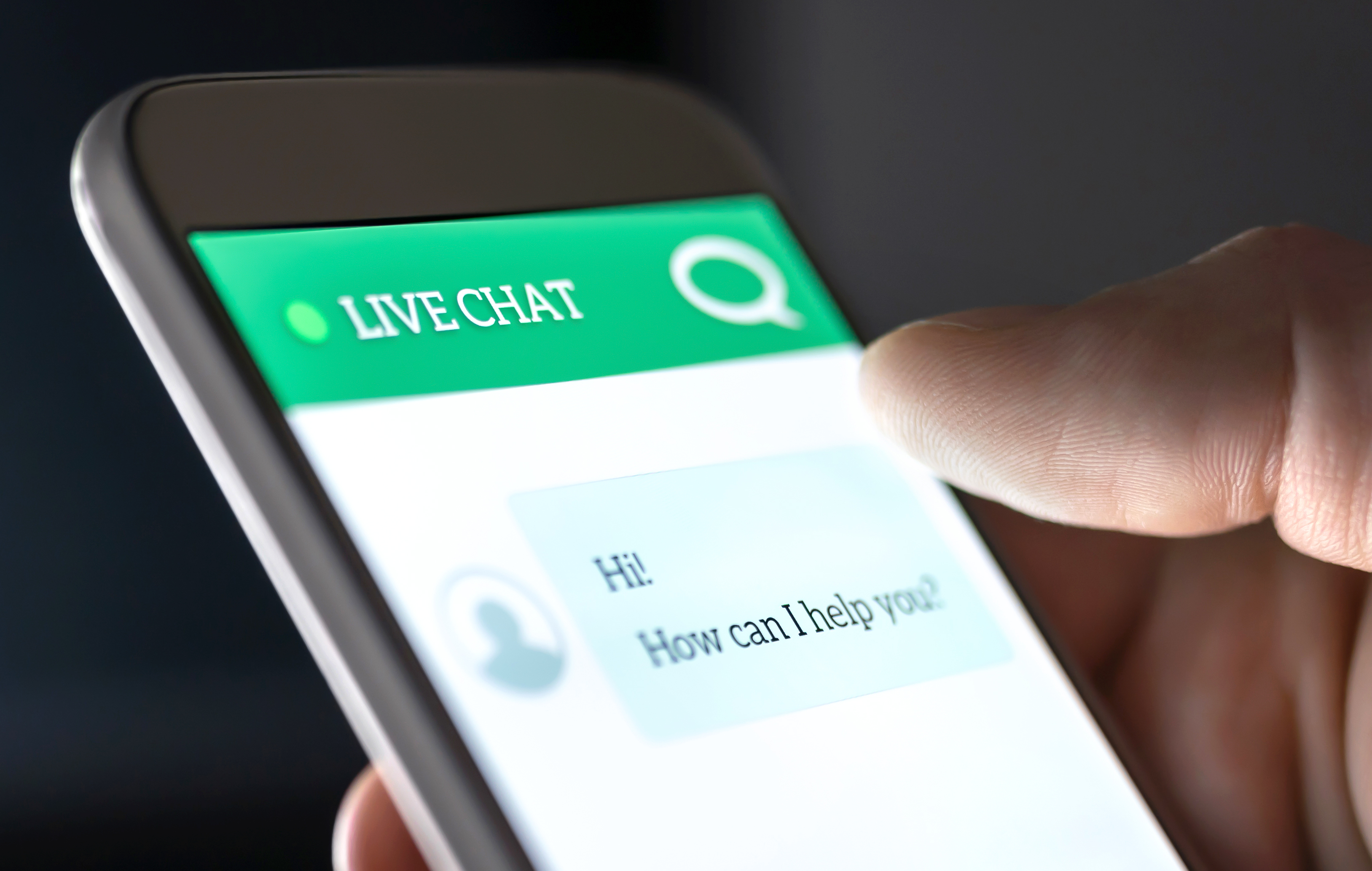 stock close up photo of phone screen with live chat and chat bubble on screen