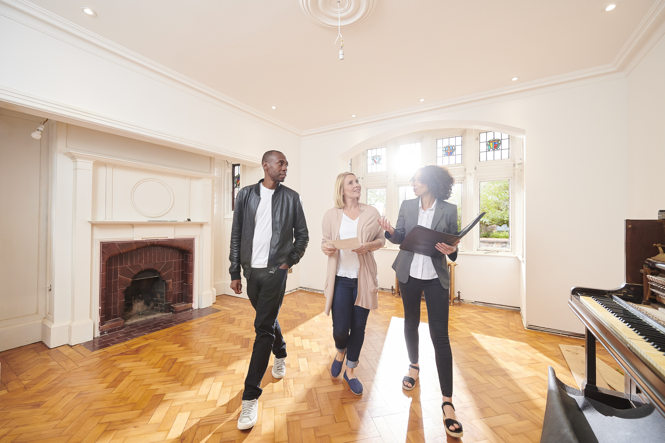 Stock photo of man and woman looking at interior of home with a real estate agent
