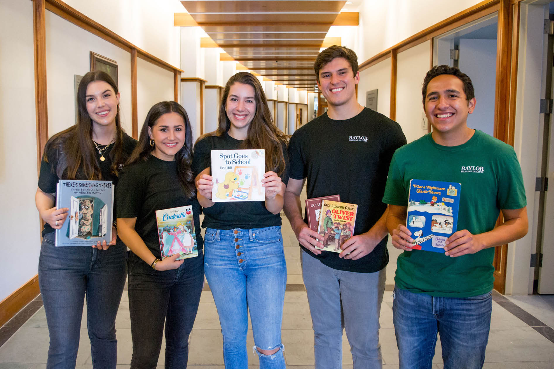 Five law school students holding childrens books that were donated during the Hispanic Law Student Association Book Drive in early 2022